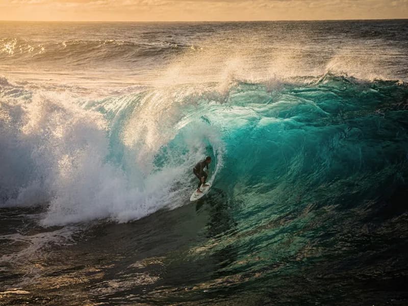 Aerial cinematic shot of a surfer riding a turquoise wave at golden hour, demonstrating Nano Banana 2 AI camera control capabilities